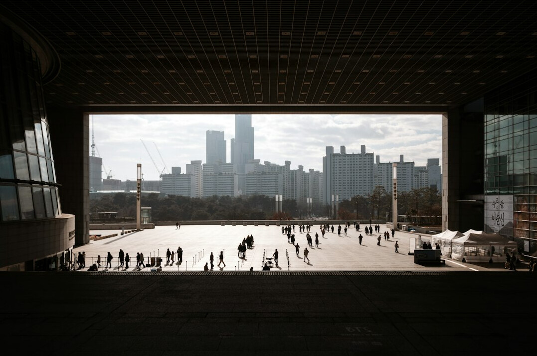 Distant silhouettes of a crowd of people walking in an urban plaza
